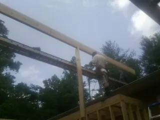 Carpenter setting a ridge beam over a new addition frame — Ice Dam Removal by Roofing Brothers in Rushmore