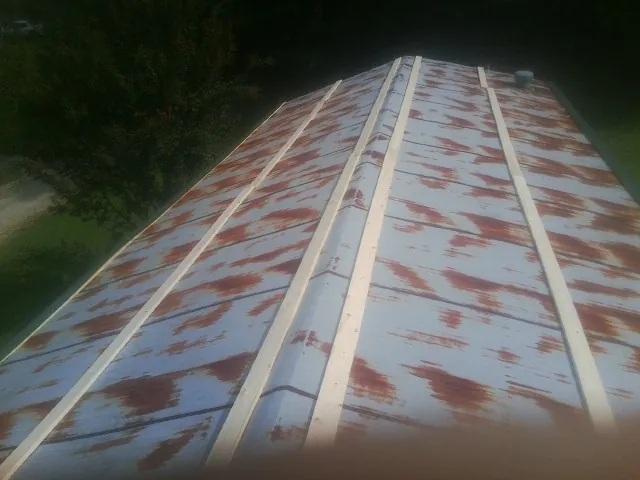 Rusted metal roof panels with new wood purlins before replacement — Storm Damage Roof Repair in Rushmore by Roofing Brothers